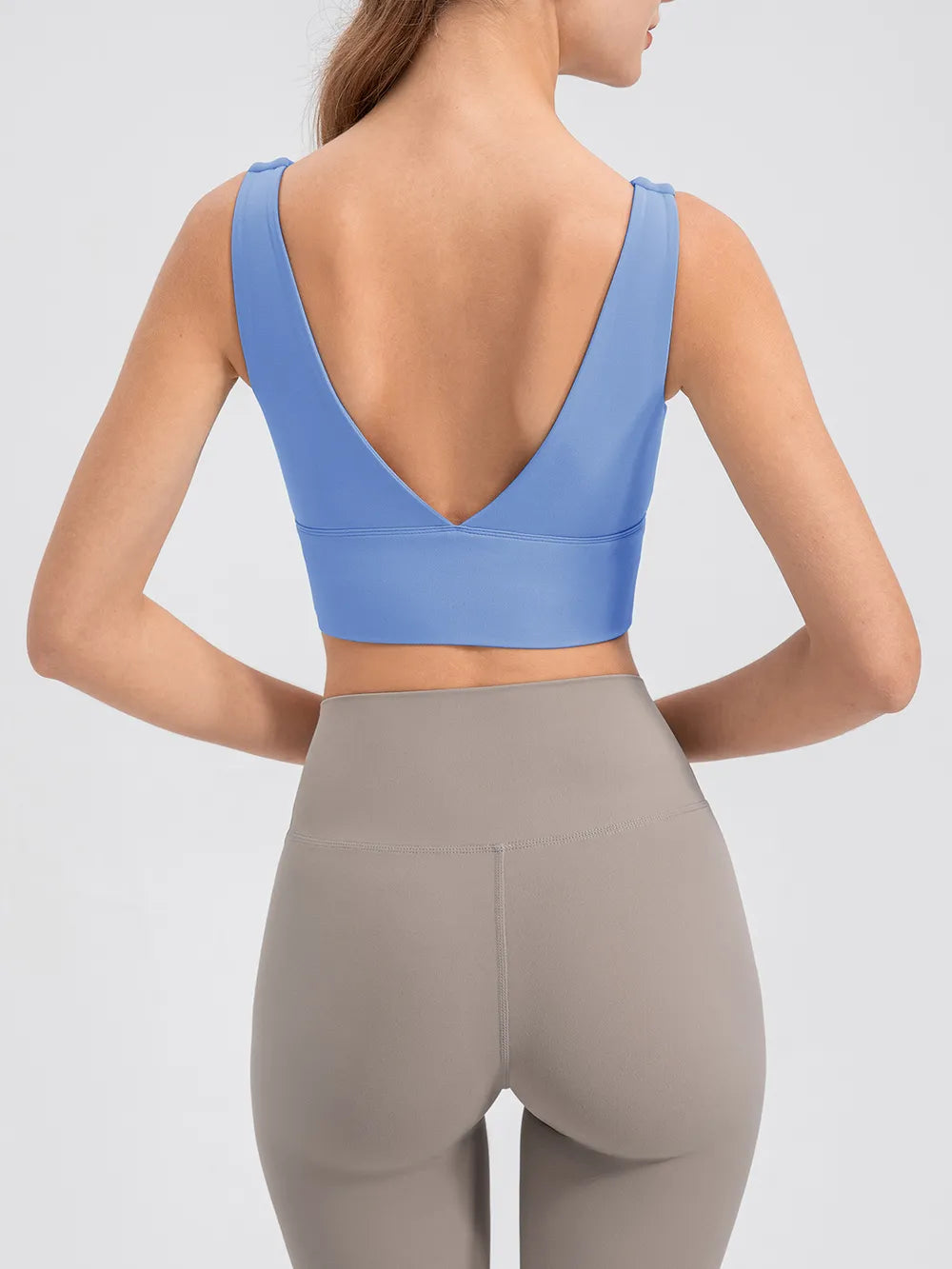 Back view of the blue cropped tank with a deep V-shaped neckline