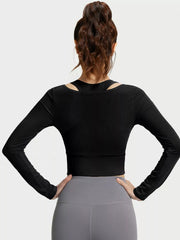 Rear view of black long-sleeve cropped active top with inner racerback shoulder cutouts