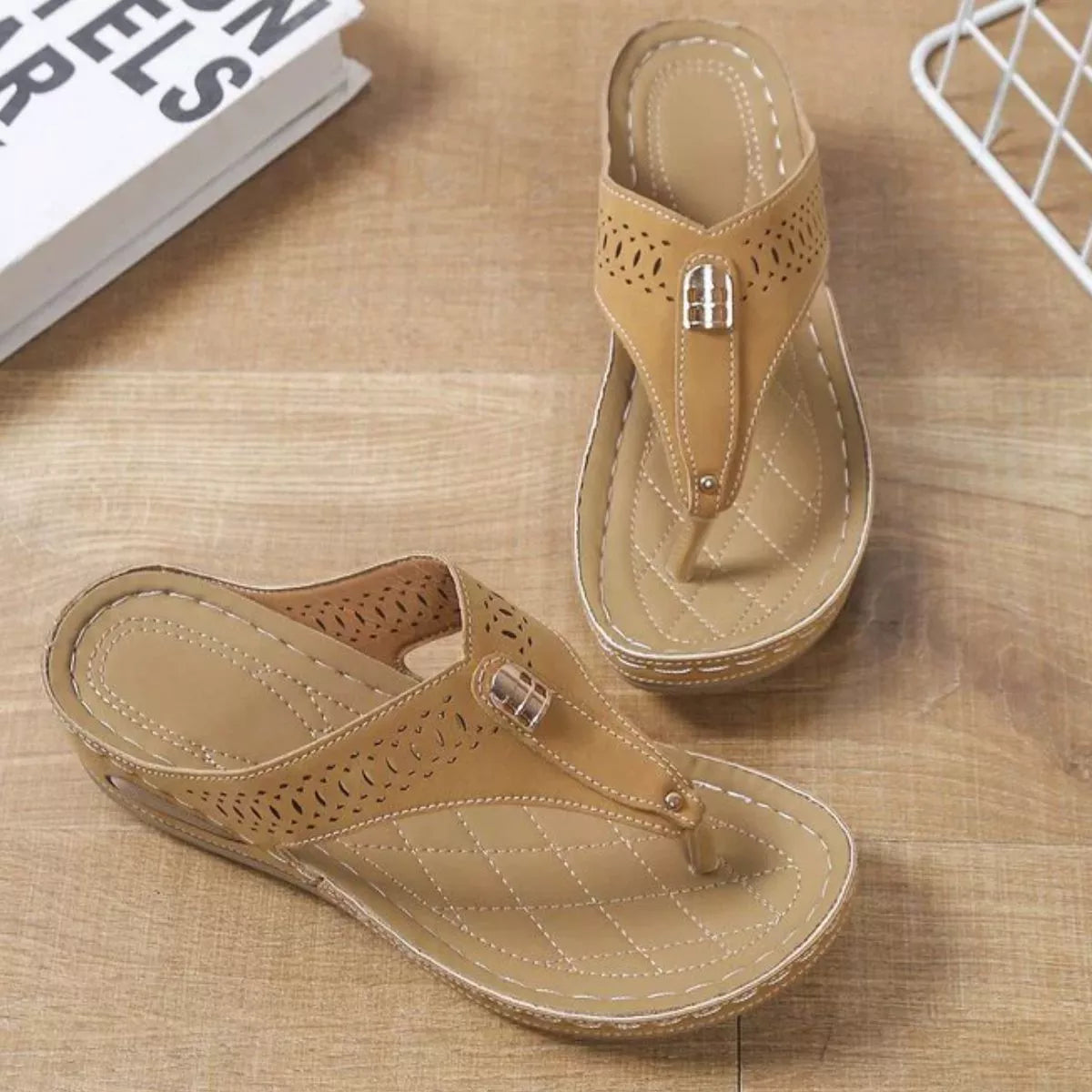 Pair of taupe perforated toe-post wedge sandals shown from above