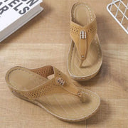Pair of taupe perforated toe-post wedge sandals shown from above
