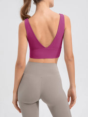Model wearing the magenta cropped tank with taupe leggings