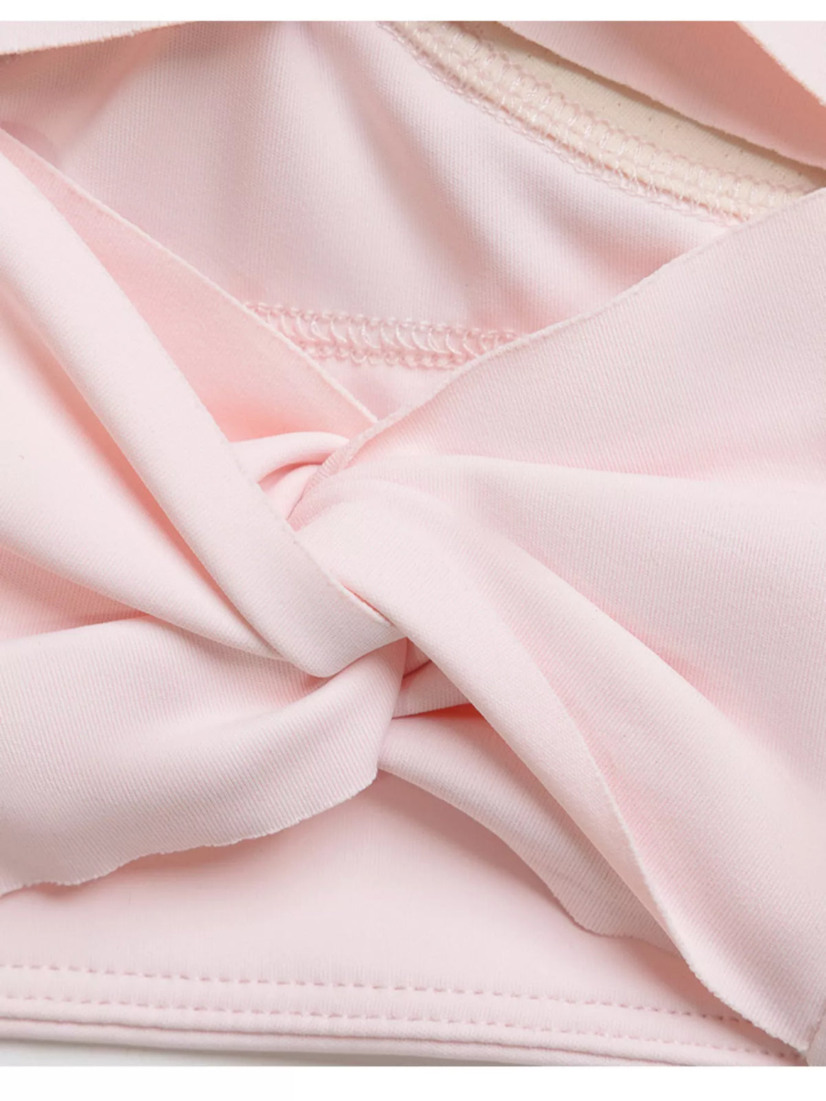Close-up of the pink active bra's twisted back band and stitching.