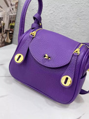 Close-up of the purple bag’s flap and gold-tone turn-lock closure
