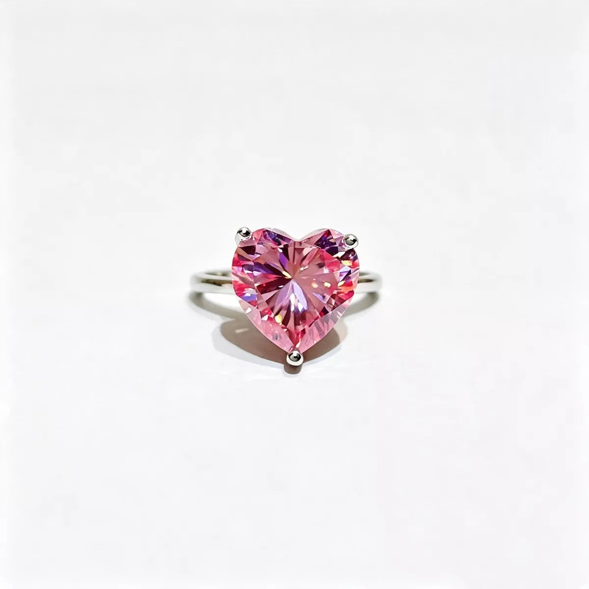 Pink heart-shaped moissanite ring shown from the front.