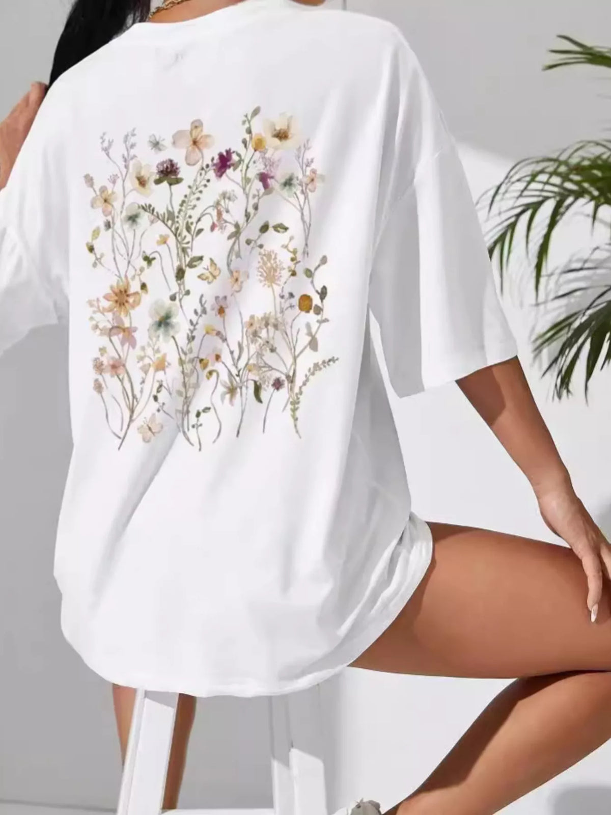 White oversized short-sleeve tee with large wildflower print across the back