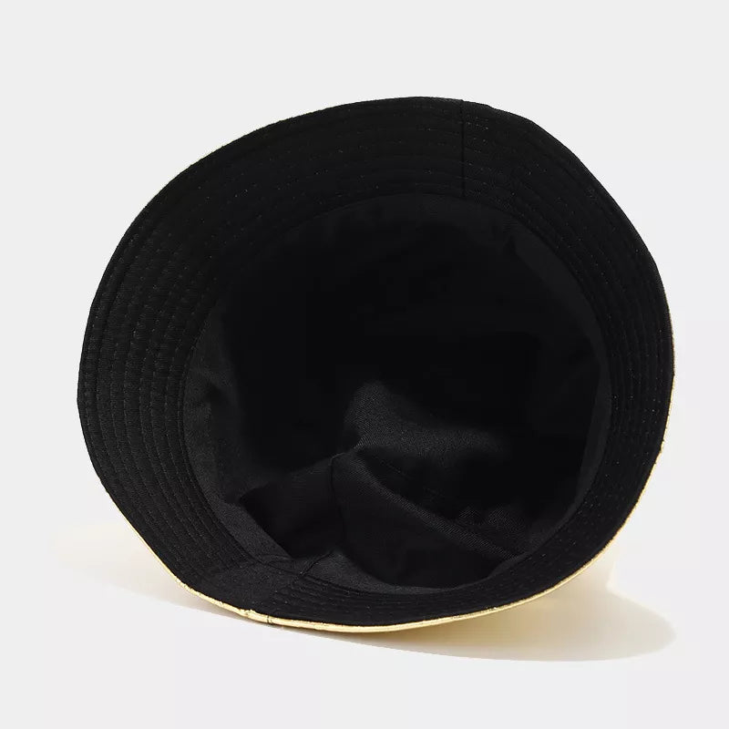 Close-up of gold bucket hat with rows of stitching along the brim