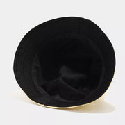 Close-up of gold bucket hat with rows of stitching along the brim