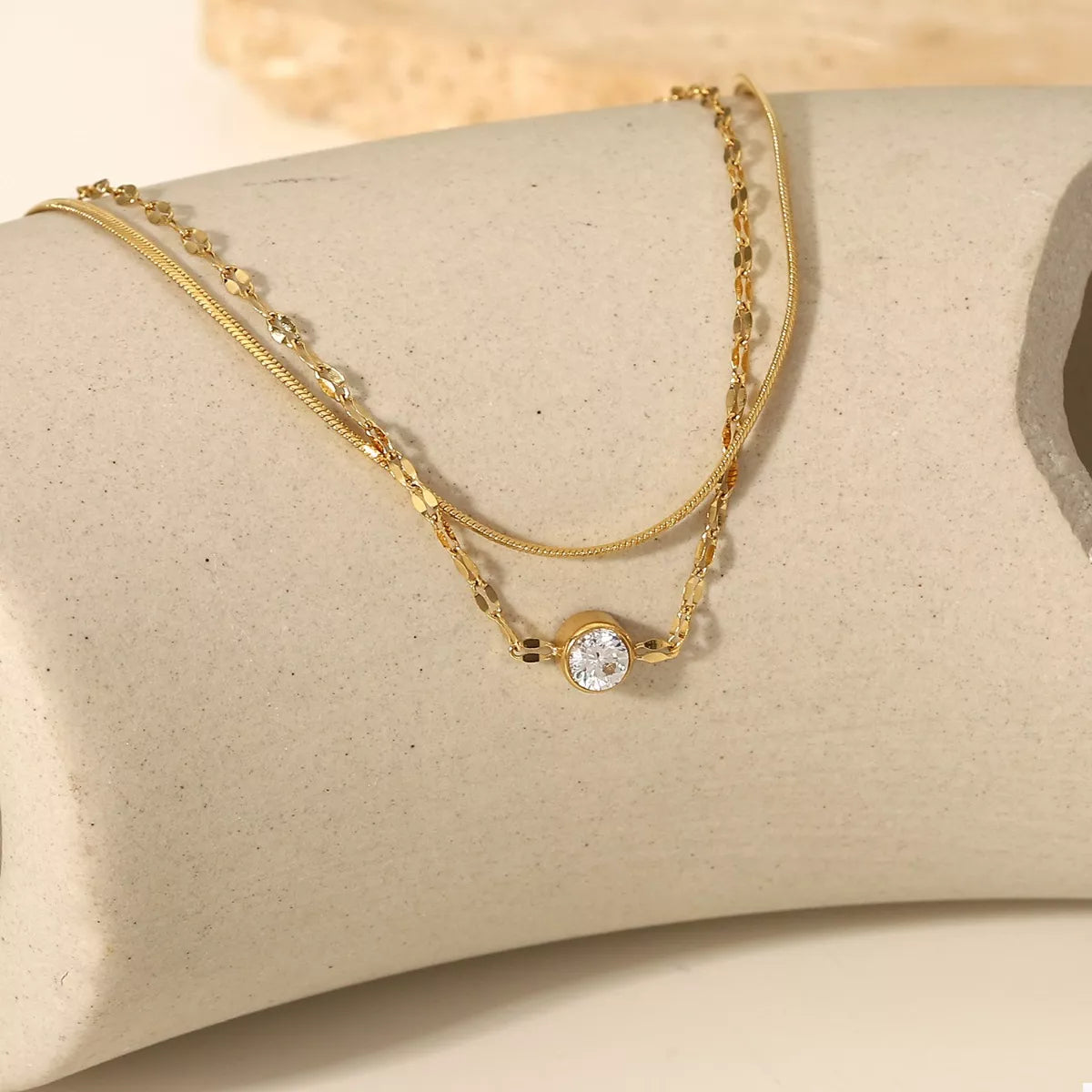 Detail of gold-tone links and clear zircon stones