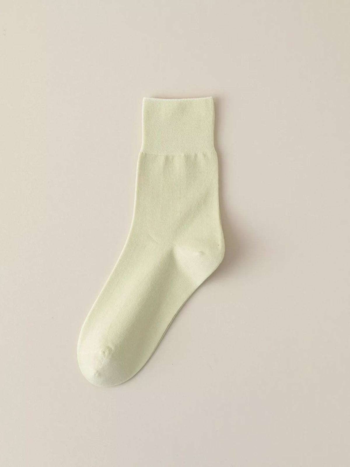 Pale green solid-color crew sock displayed flat