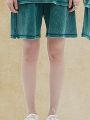 Model wearing deep teal elastic-waist shorts
