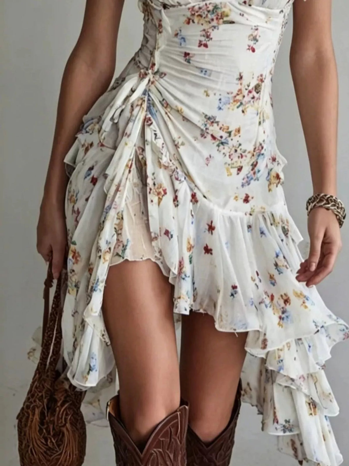 Close view of the floral print, gathered waist and cascading asymmetric ruffle hem