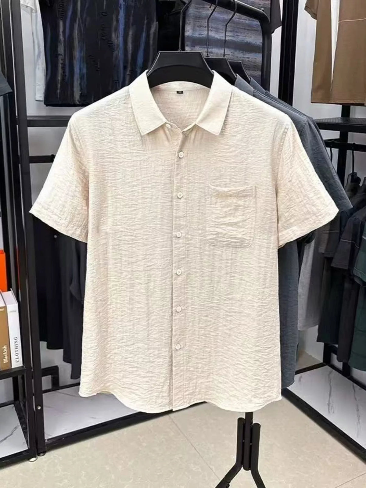 Cream textured short-sleeve button-up shirt on a hanger