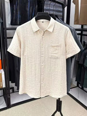 Cream textured short-sleeve button-up shirt on a hanger