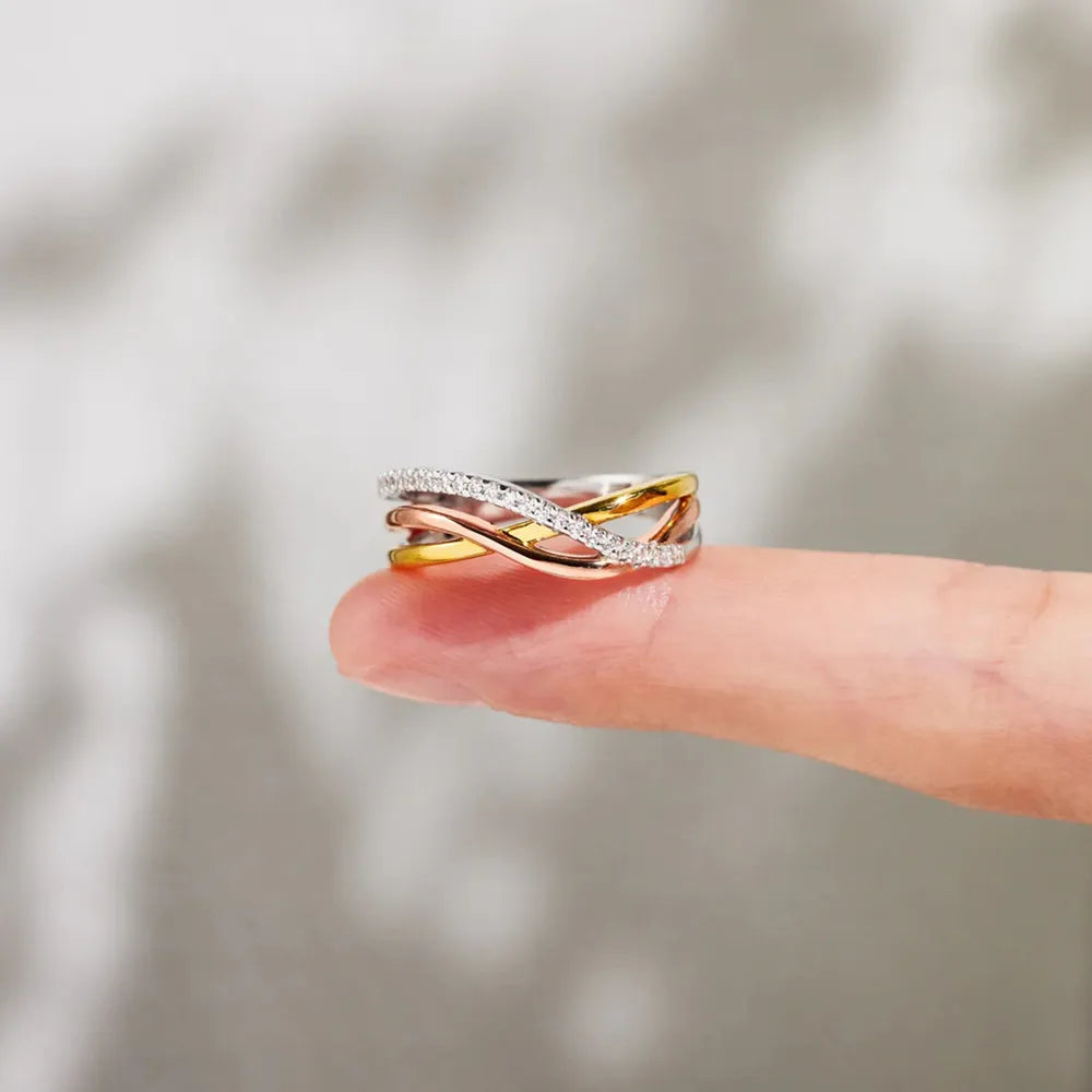 Gold-plated sterling silver crisscross ring shown from the side on a fingertip