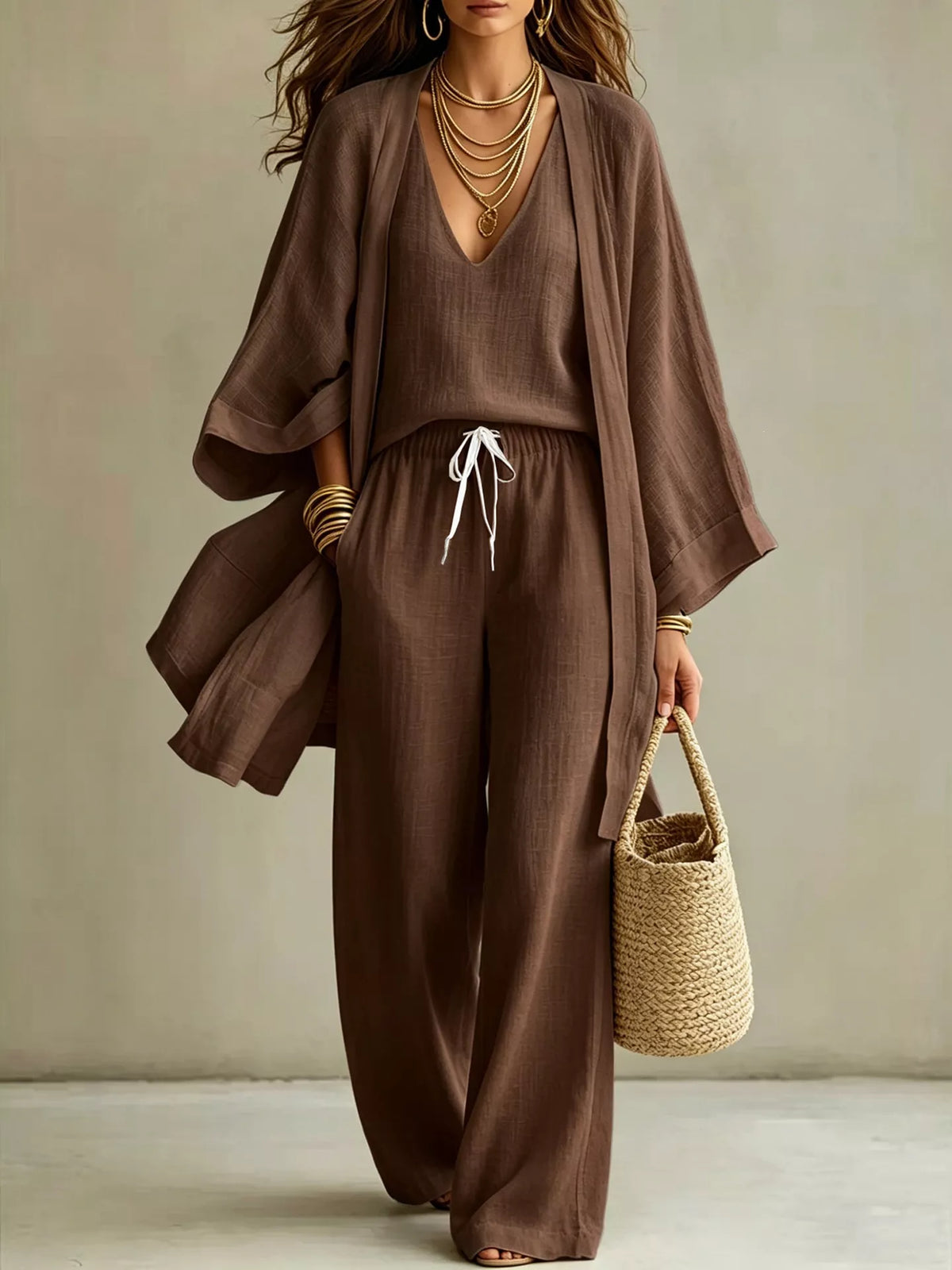 Woman wearing a brown cardigan and matching pants from the three-piece set.