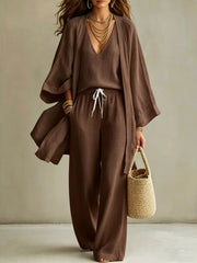 Woman wearing a brown cardigan and matching pants from the three-piece set.