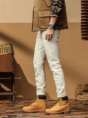 Opposite side view of off-white jeans with knee seams and rolled hems
