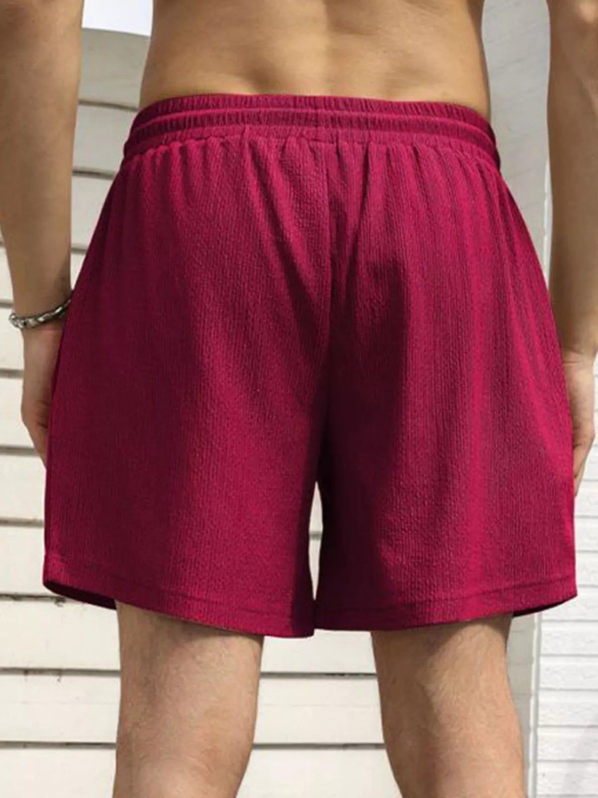 Model wearing magenta drawstring shorts, rear view