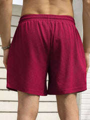 Model wearing magenta drawstring shorts, rear view