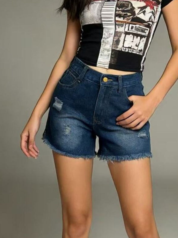 Model wearing medium-wash distressed denim shorts
