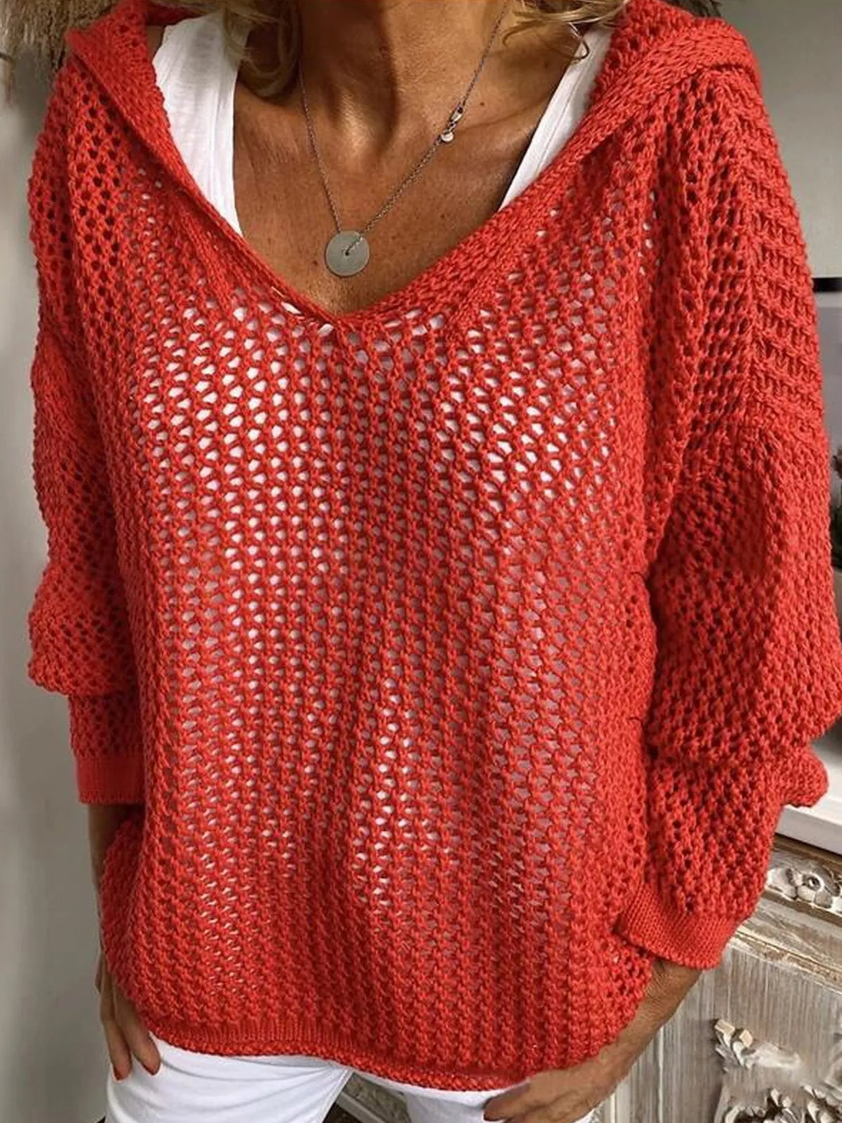 Red open-knit long-sleeve hooded cover-up worn over a white top, front view.