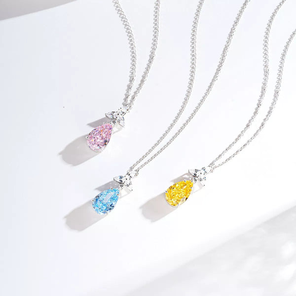 Three teardrop zircon pendants in blush pink, pastel blue and light yellow on white