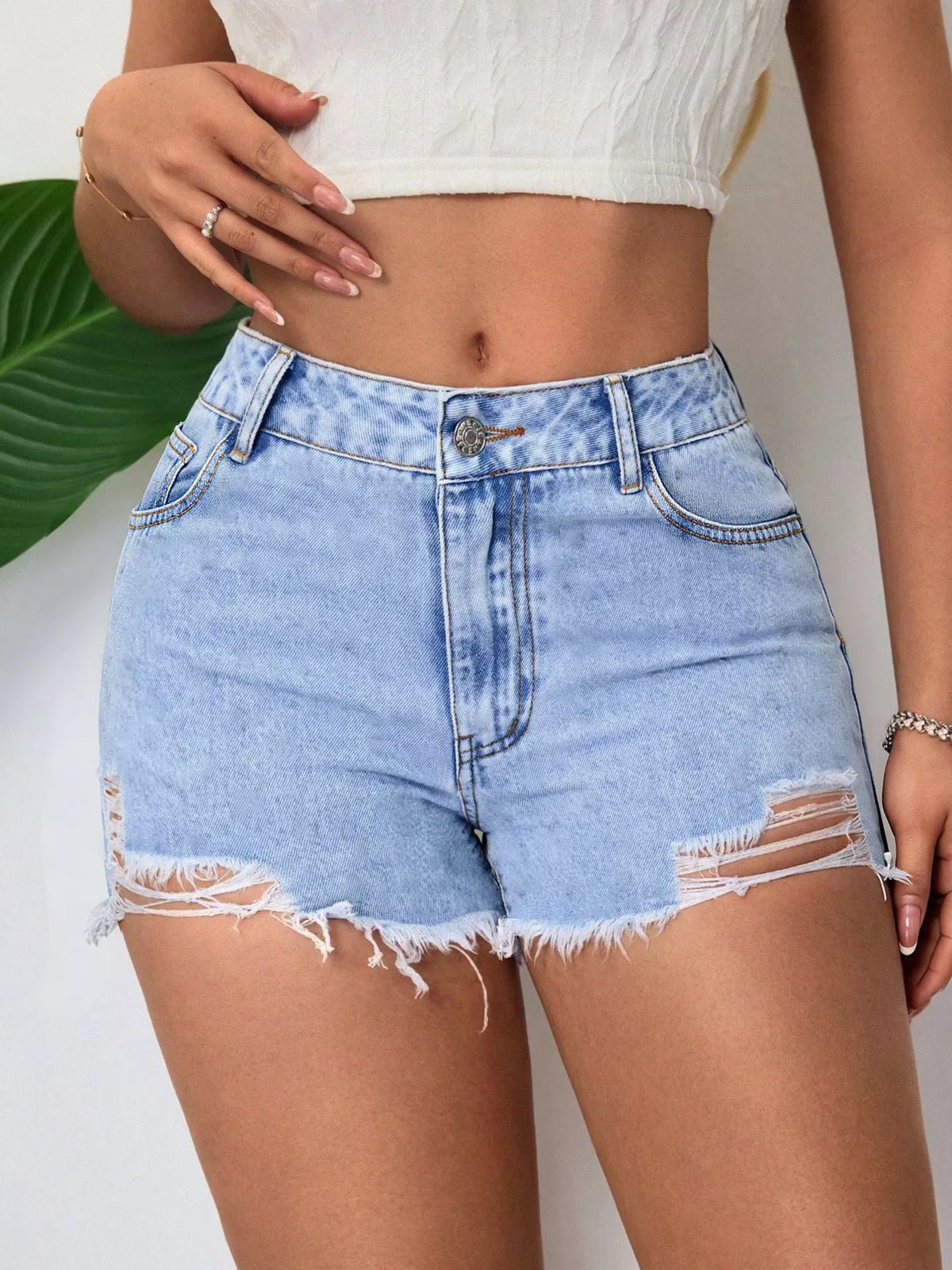 Front view highlighting distressed rips and frayed hems on denim shorts
