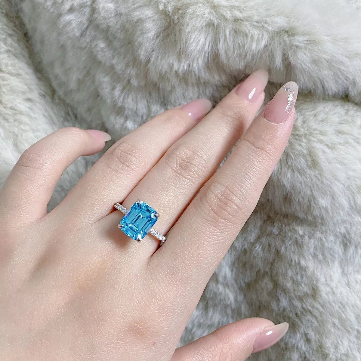 Silver ring with a cushion-shaped center stone in a scalloped halo, three-quarter view.