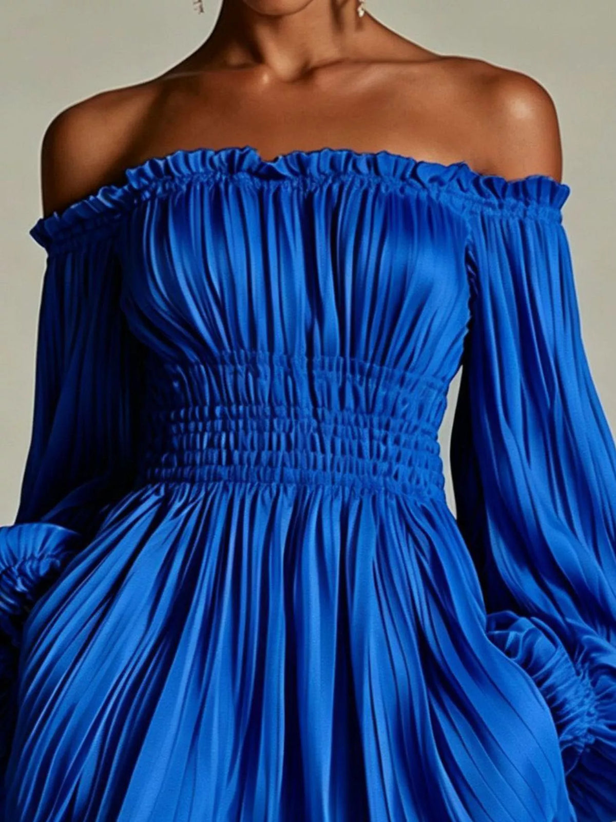 Model wearing the bright blue version of the pleated off-shoulder mini dress