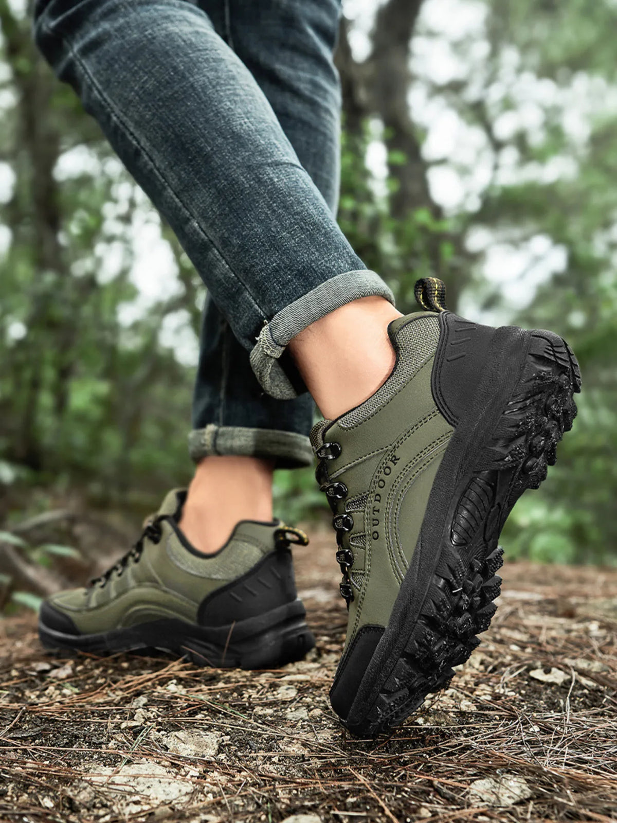 Olive green and black lace-up shoes shown from the side on a forest log