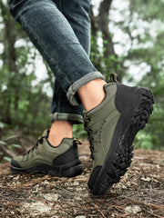 Olive green and black lace-up shoes shown from the side on a forest log