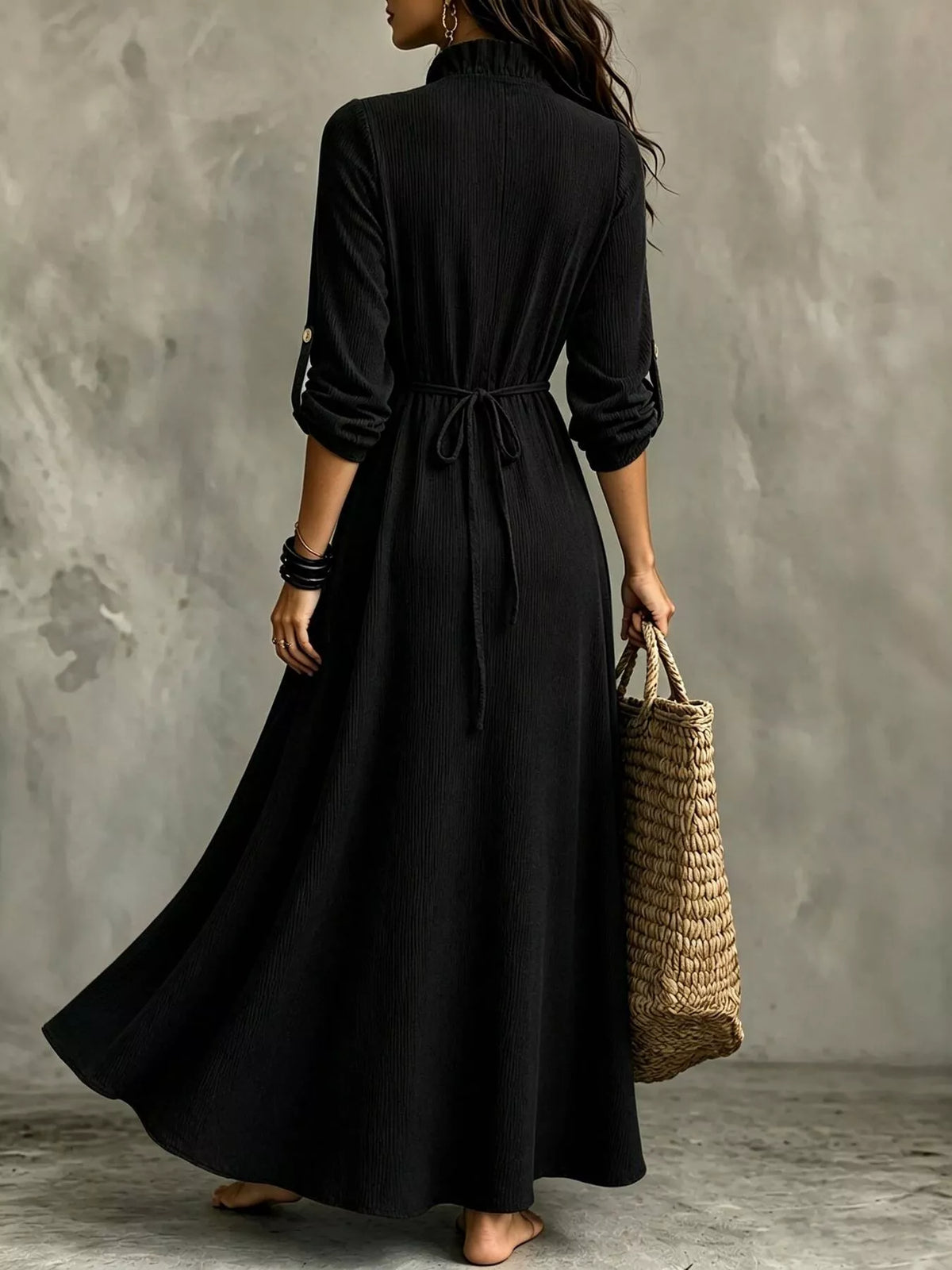 Back view of black maxi dress showing waist tie and flowing skirt
