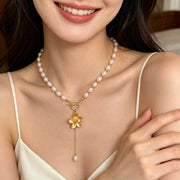 Pearl choker and gold flower pendant shown on a smiling model