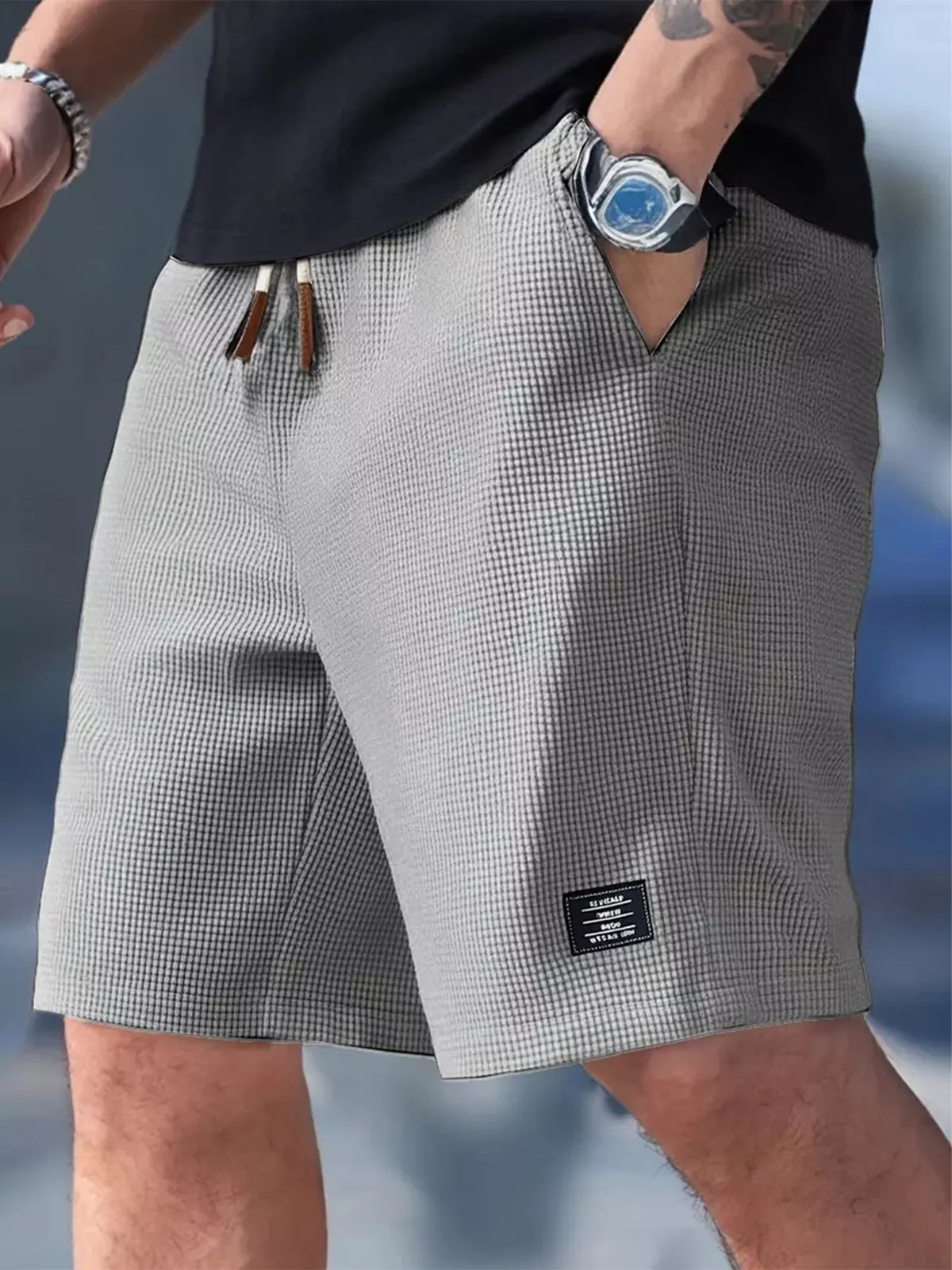 Grey waffle-knit drawstring shorts shown from the front on a model