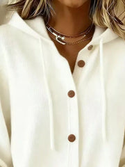 Close view of white cardigan hood and brown button placket