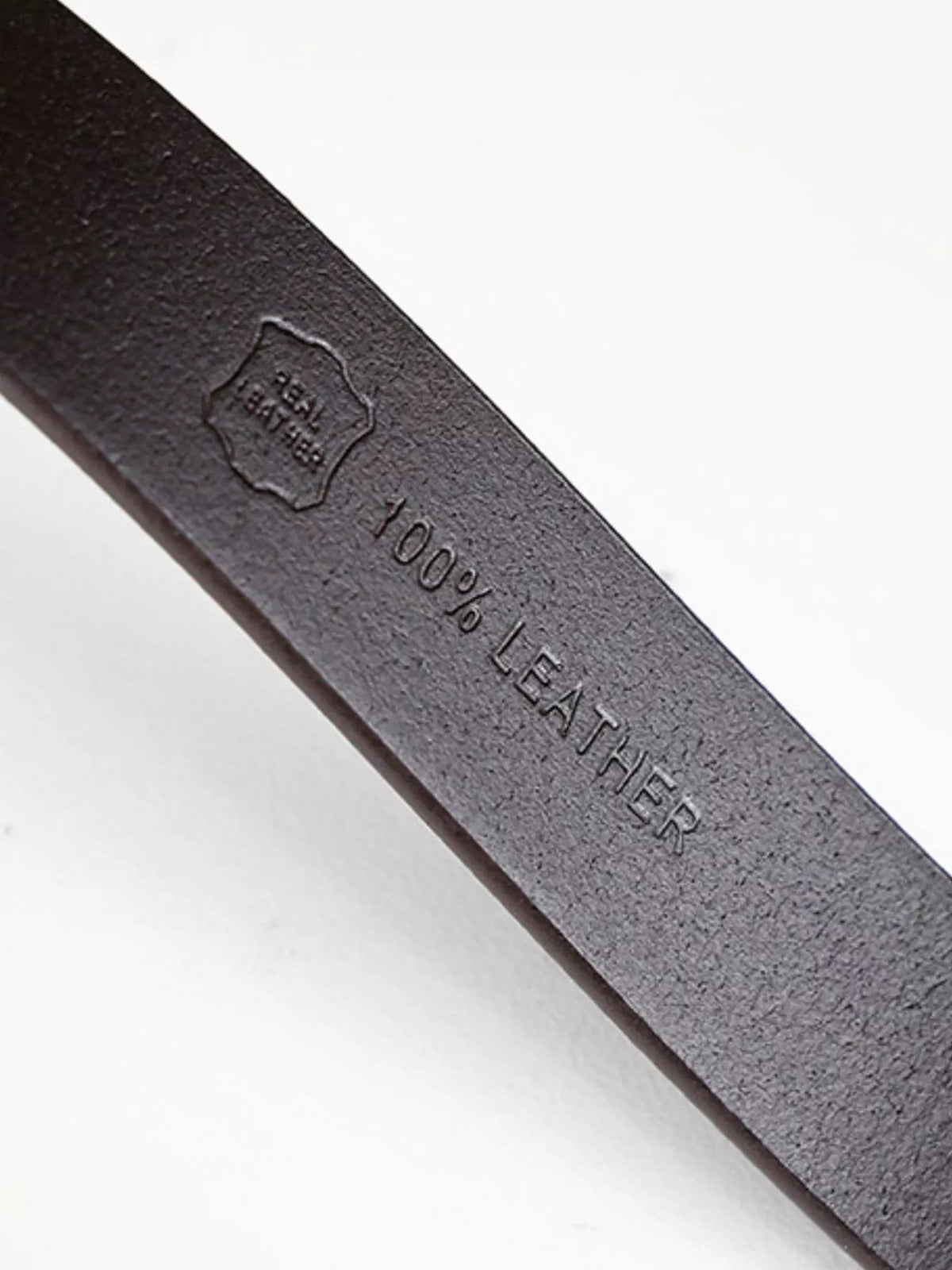 Embossed 100% LEATHER marking on the underside of a black belt