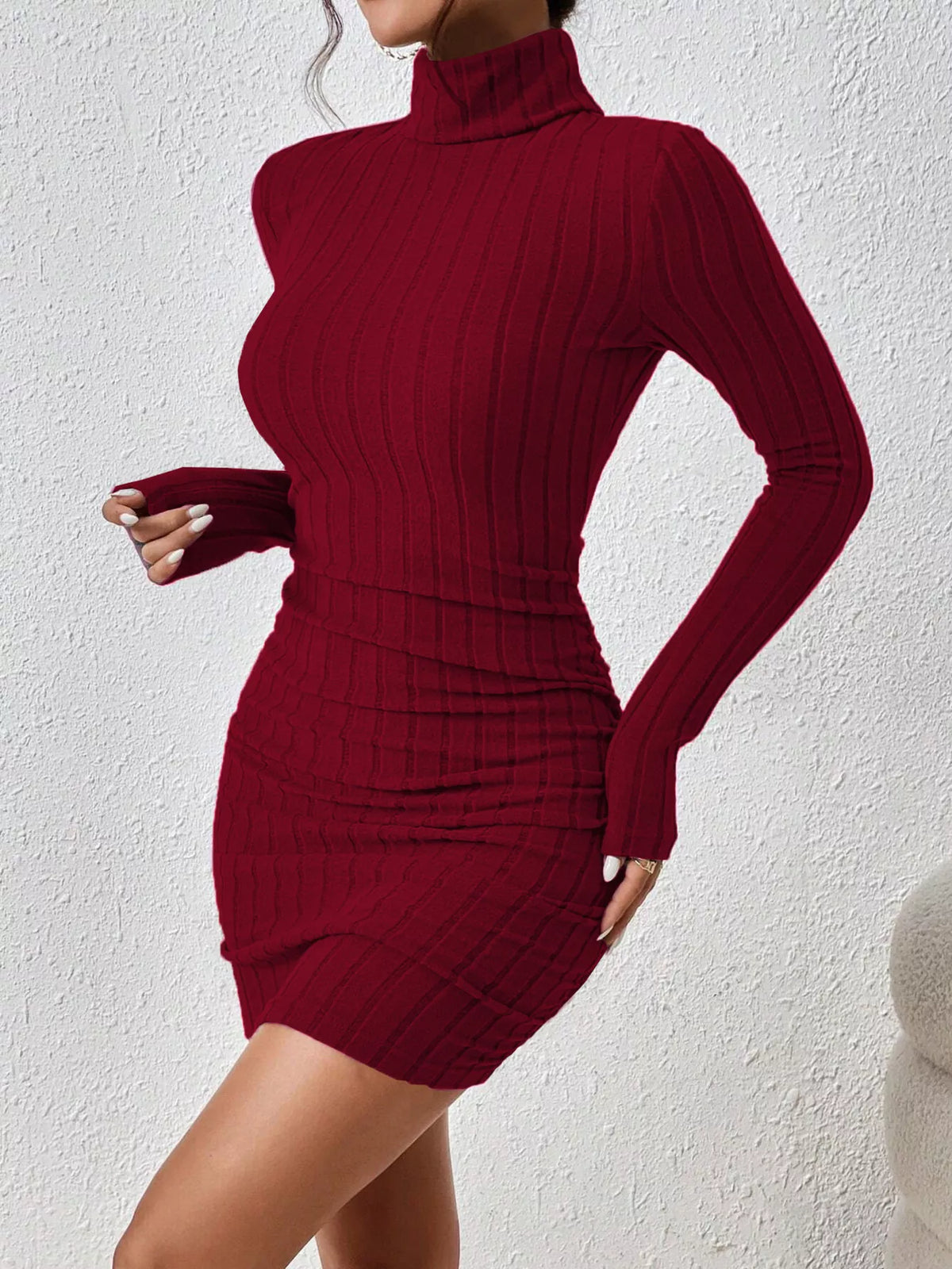 Burgundy long-sleeve ribbed mini dress shown at an angle with a fitted waist and high neck.