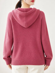 Back view of the dusty pink sweater showing its hood and ribbed hem.