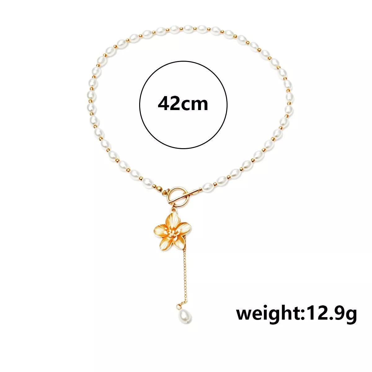 Pearl choker with gold flower pendant and dangling pearl, worn with a floral top