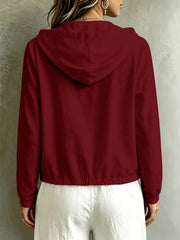 Back view of the burgundy blouse with hood and drawstring hem.