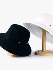 Black and white wide-brim sun hats displayed on wooden stands