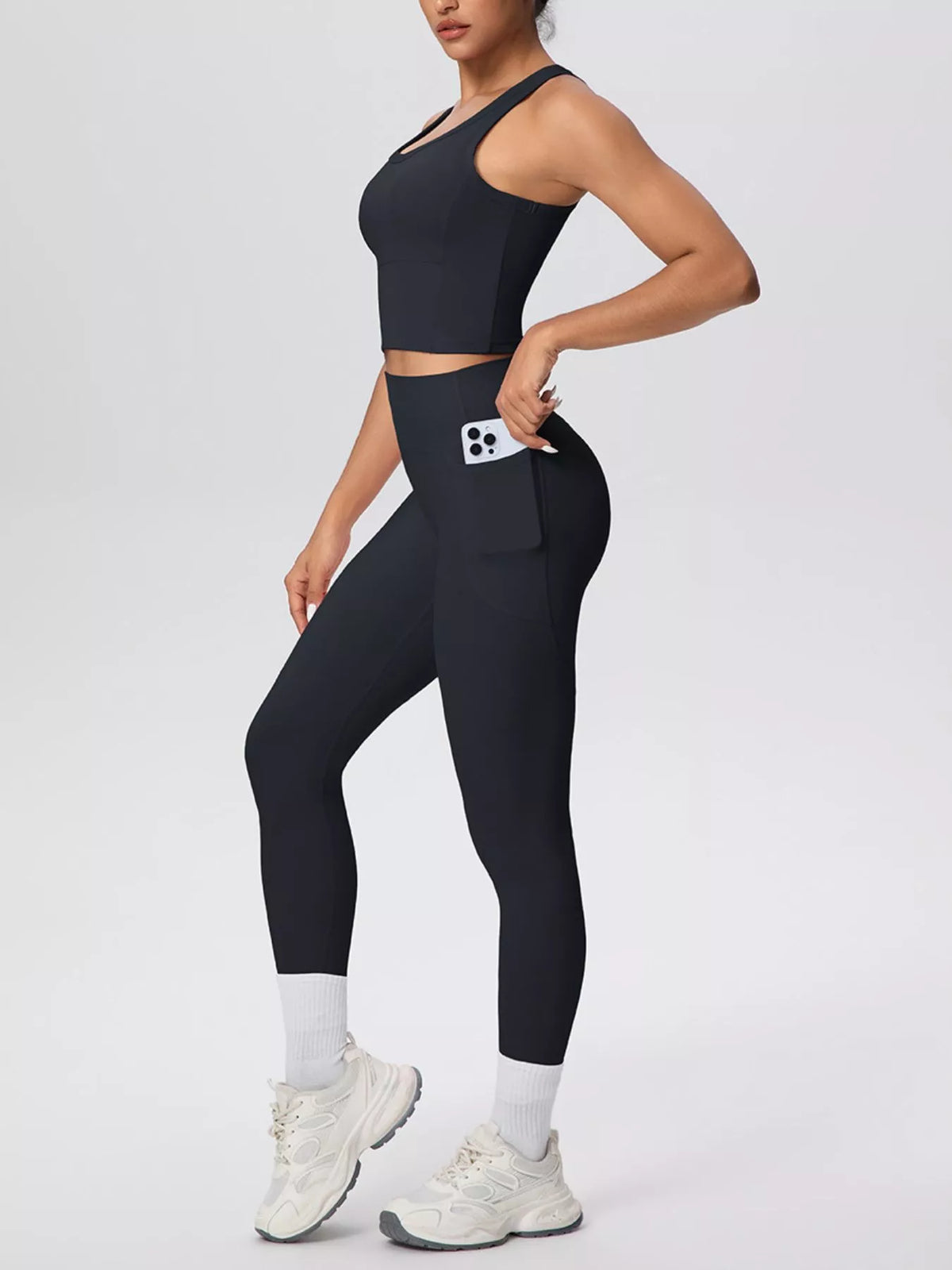 Black workout set in side view with phone in leggings pocket