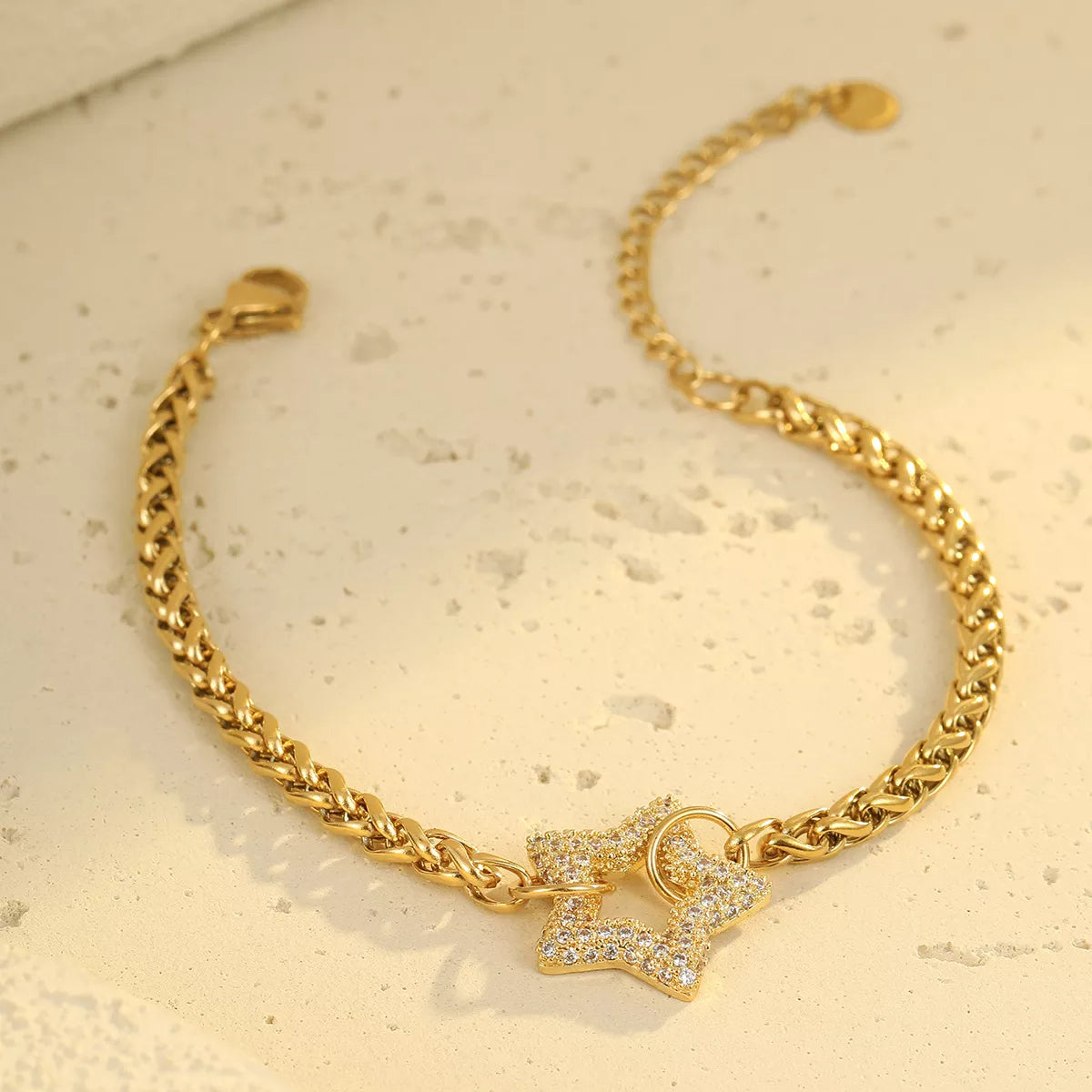 Gold-tone chain bracelet with rhinestone centerpiece on pale surface