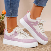 Pink and white platform sneakers worn with jeans