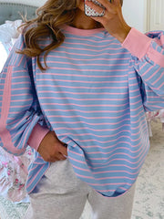 Model wearing blue and pink striped sweatshirt with contrast trim