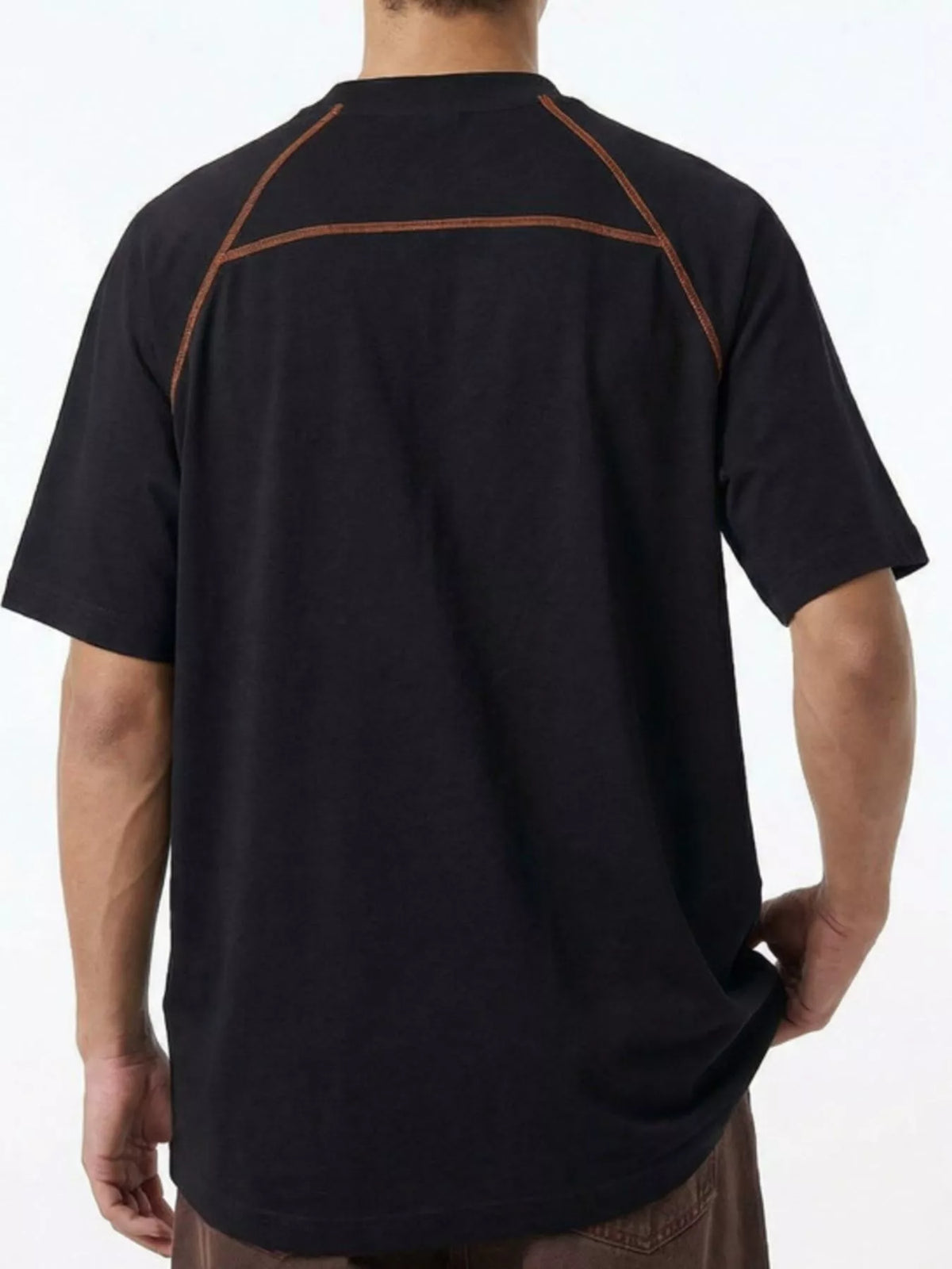 Back view of model wearing black T-shirt with contrast piping