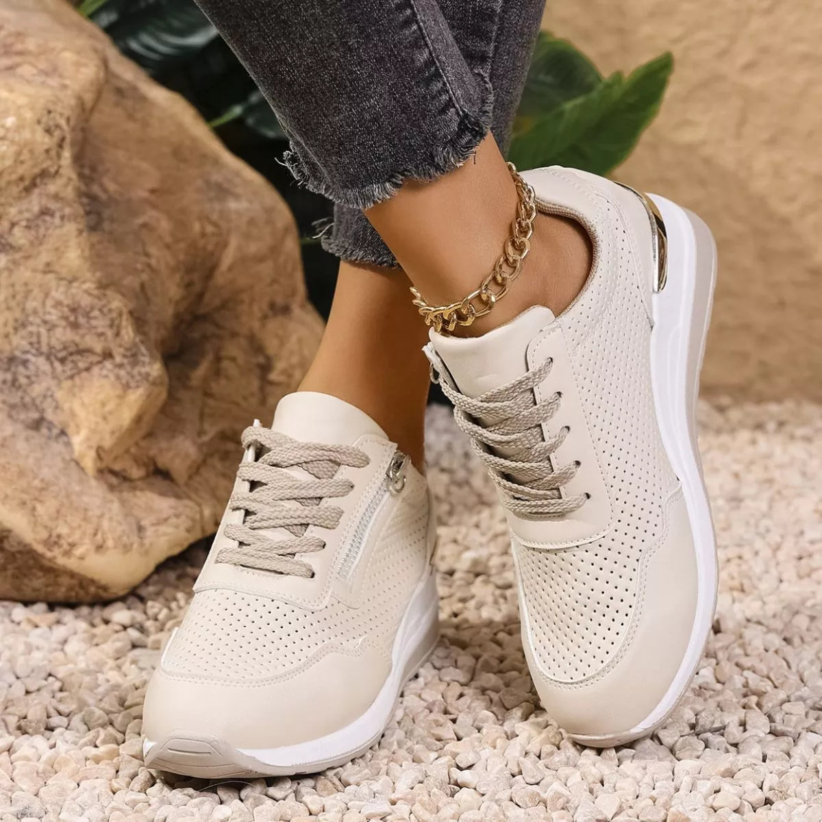 Pair of cream knit lace-up sneakers worn with jeans