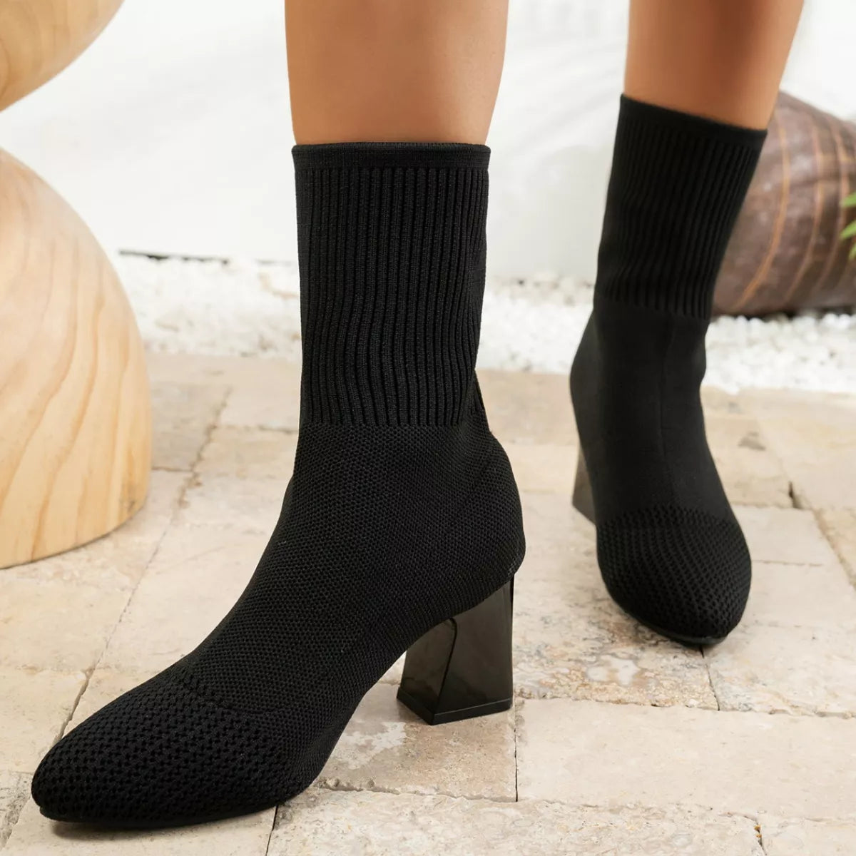 Front view of black knit sock boots with pointed toes and block heels