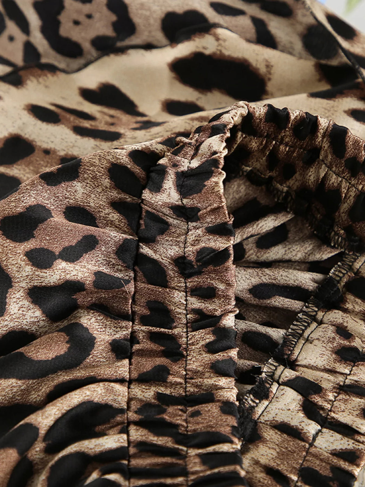 Interior gathered seam and elastic edge of leopard-print garment