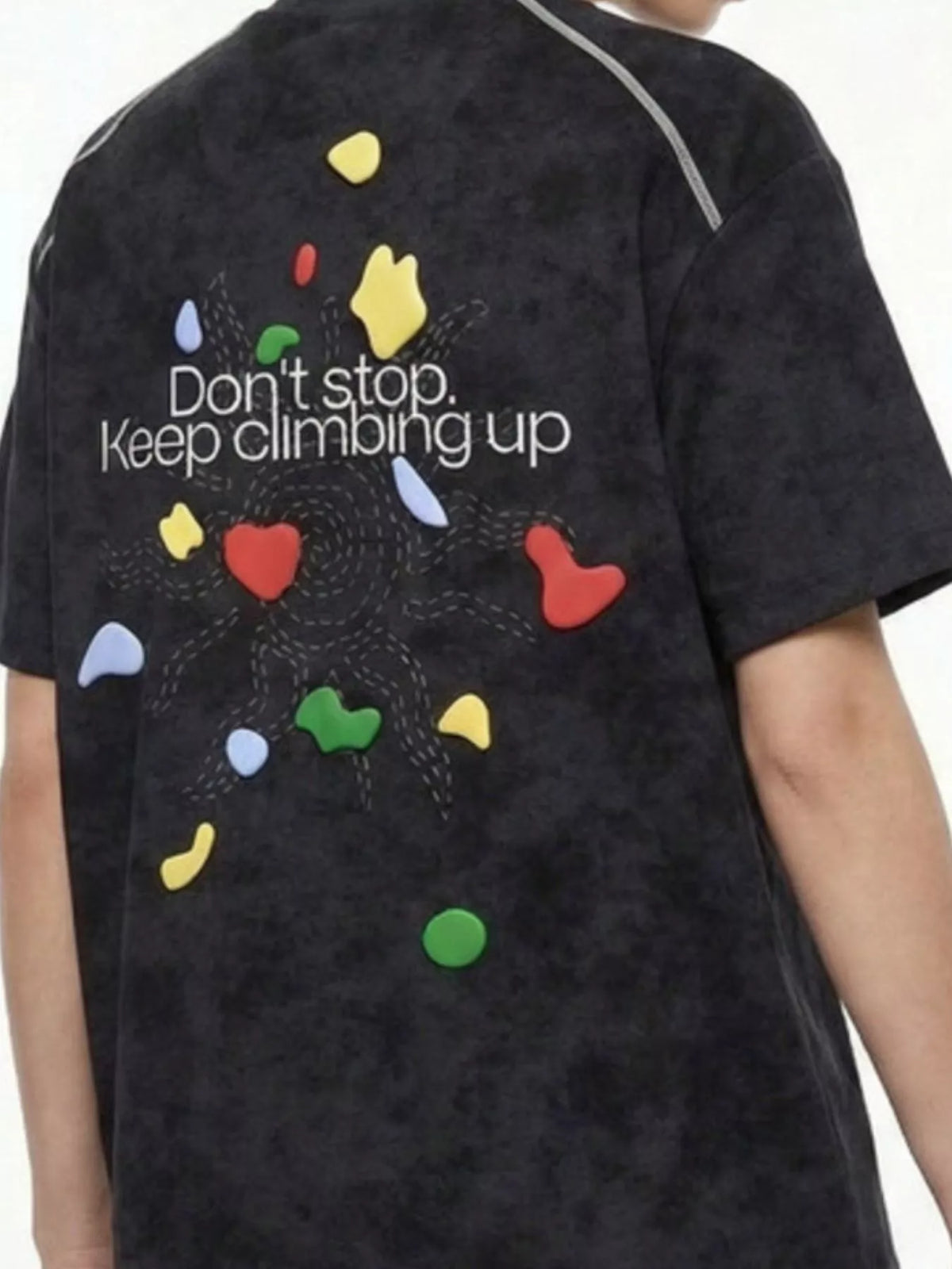 Back view of black T-shirt with colorful hearts and “Don’t stop, keep climbing up” graphic